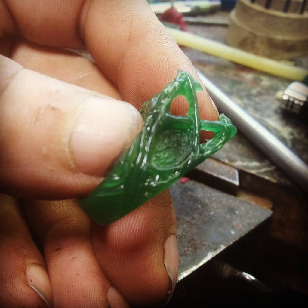   hand holding a custom carved wax ring blank. 