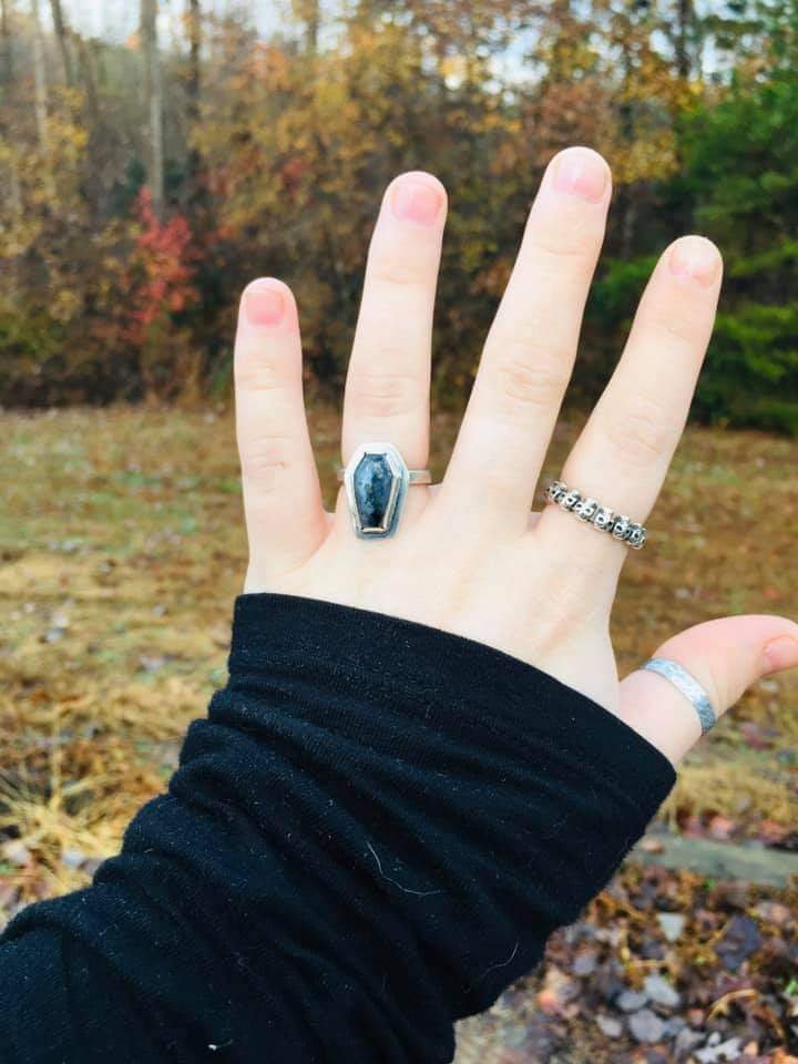 womans hand wearing a coffin ring